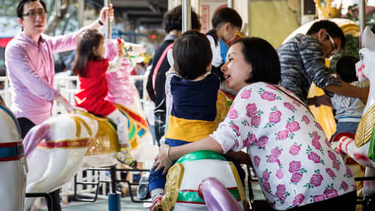 Adults and children ride on a carousel at Lu Xun Park in Shanghai, Oct. 24, 2015.