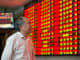 An investor observes stock market at a stock exchange hall in Nanjing, Jiangsu Province of China. 