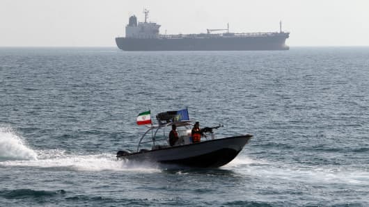 Iranian Revolutionary Guards drive a speedboat in front of an oil tanker at the port of Bandar Abbas.
