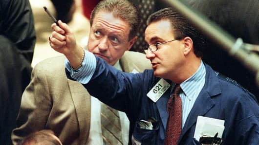 A day after the Dow Jones Industrial Average dropped over 231 points, traders on the floor of the New York Stock Exchange monitor early trading 13 October, 1999.
