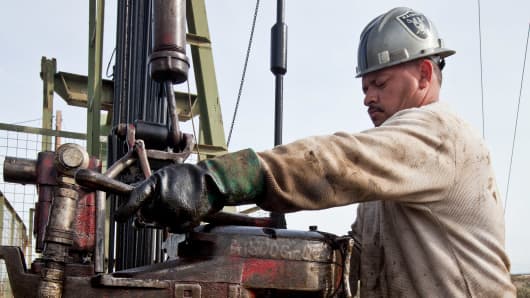 Una persona que trabaja en el piso opera una plataforma de perforación de petróleo Chevron cerca de Taft, California.