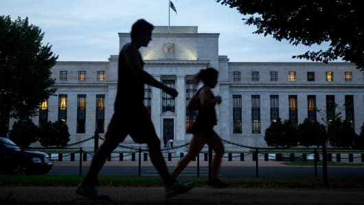 Pedestrians walk past the Federal Reserve building in Washington.