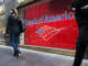 Pedestrians pass in front of a Bank of America branch in New York City.