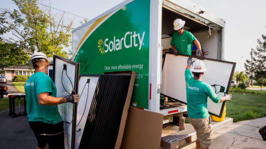 SolarCity employees unload solar panels from a truck during a home installation in Kendall Park, New Jersey.