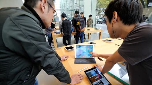 An apple shop assistant demonstrates an Ipad pro at the Apple store of the High-end shopping district of Omotesando in Tokyo, Japan.