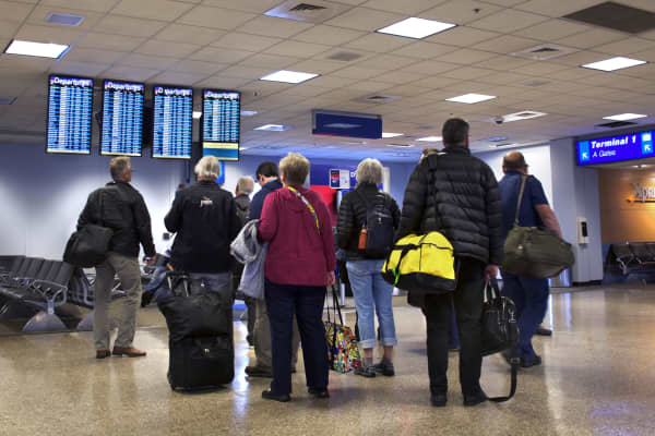 Airplane passengers check their flights on departure boards at Salt Lake City International Airport in Salt Lake City, Utah.