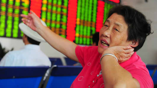 An investor observes stock market at a stock exchange hall in Fuyang, Anhui Province of China.