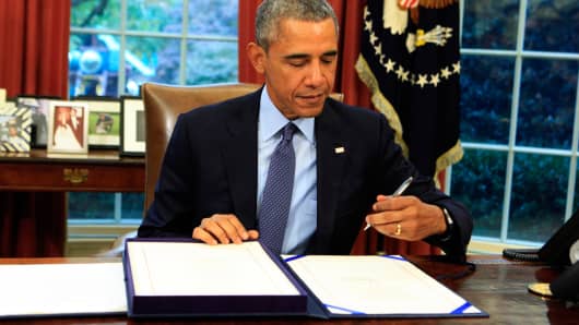 President Barack Obama signs the bipartisan budget bill in the Oval Office of the White House, November 2, 2015.