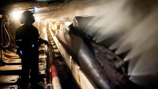 Coal miners operate a carbide-tipped shearer as it scrapes coal at a mine in Wind Ridge, Pennsylvania.