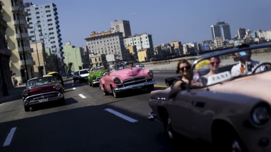 Tourists ride in a vintage car at the 'Malecon' seafront in Havana, March 16, 2016.