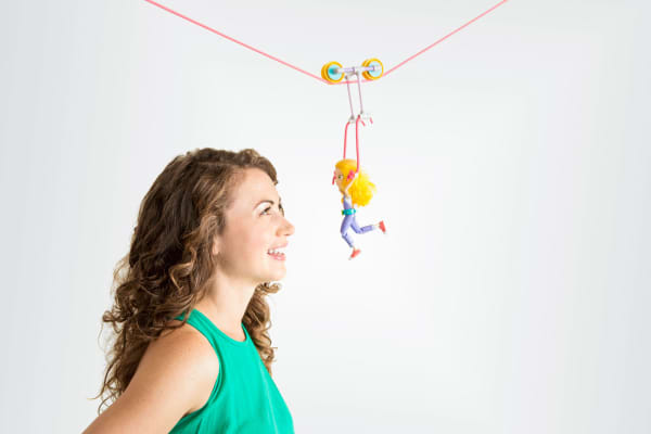 Debbie Sterling, the founder of GoldieBlox, and “Goldie” on a zipline made with GoldieBlox.