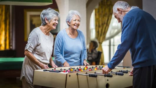 Senior people playing foosball at nursing home