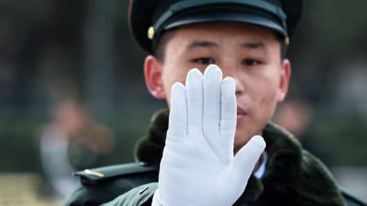 A security guard gestures outside the Great Hall of the People in Beijing, China.