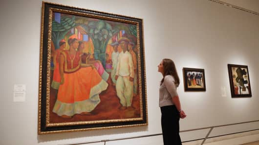 A woman views a painting by Diego Rivera entitled 'Dance in Tehuantepec' in the Royal Academy of Arts on July 2, 2013 in London, England.