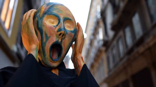 A costumed reveller wearing a mask depicting Munch's famous painting 'The Scream' poses near St Mark's square during the carnival on February 21, 2014 in Venice. 
