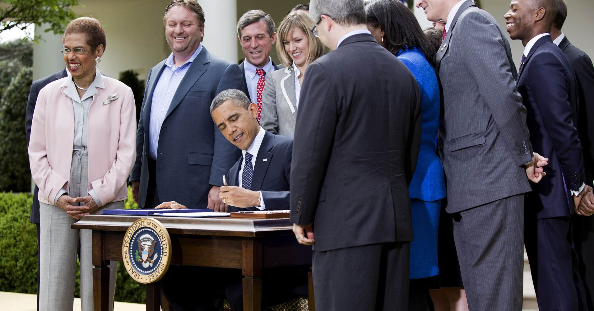 President Barack Obama, surrounded by members of Congress and business leaders, signs the Jumpstart Our Business Startups (JOBS) Act in the Rose Garden of the White House on April 5 2012 in Washington, DC.