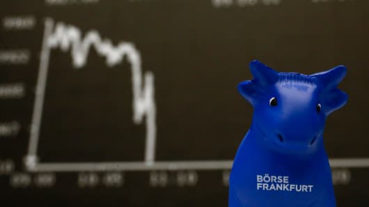 A plastic bull figurine, symbol of the Frankfurt stock exchange is pictured in front of the German share price index DAX board at the Frankfurt stock exchange.