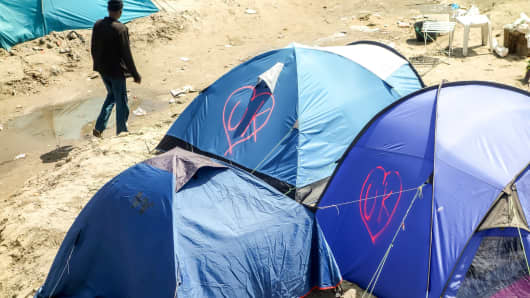 The initials of the United Kingdom, UK, are seen tagged into a heart-shape logo onto some tents of migrants inside the 'Jungle' camp for migrants and refugees in Calais on June 24, 2016.
