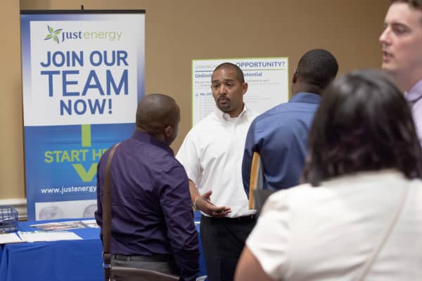 A Just Energy Group Inc. representative speaks with job seekers during the Best Hire Career Fair in Houston, Texas, U.S., on Thursday, July 7, 2016.