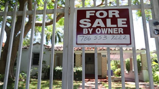 A for sale sign is seen in front of a home in Miami.