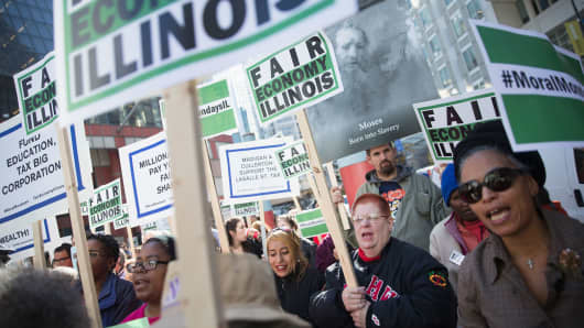 Demonstrators protesting the state of the Illinois budget stalemate rally in the Loop before marching to the Chicago Board of Trade Building, where they blocked entrances on November 2, 2015.