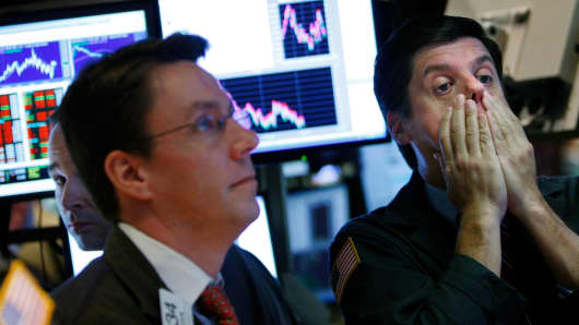 A trader rubs his face while working on the floor of the New York Stock Exchange October 7, 2008 in New York City.