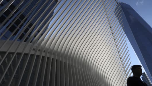 A man walks past the exterior of the Oculus Transit Hub and One World Trade Center