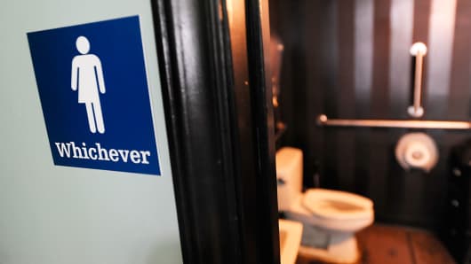 A file photo showing a gender neutral sign posted outside a bathroom at Oval Park Grill on May 11, 2016 in Durham, North Carolina.