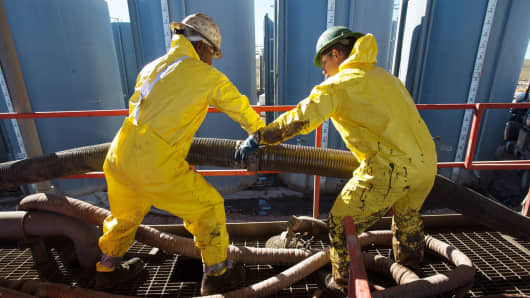 Workers connecting tubes on the Raven Oil Drilling rig near Watford City N.D.