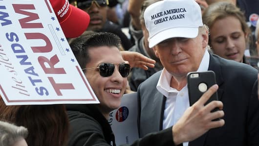 A supporter of Donald Trump takes a selfie with the Republican presidential candidate at a rally in front of the USS Wisconsin on October 31, 2015 in Norfolk, Virginia.