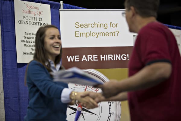 A job seeker, right, shakes the hand of a recruiter during the Quad Cities career fair in Moline, Illinois.