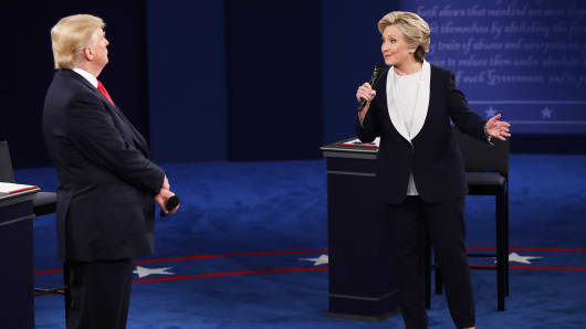 Democratic presidential nominee former Secretary of State Hillary Clinton (R) speaks as Republican presidential nominee Donald Trump listens during the town hall debate at Washington University on October 9, 2016 in St Louis, Missouri.