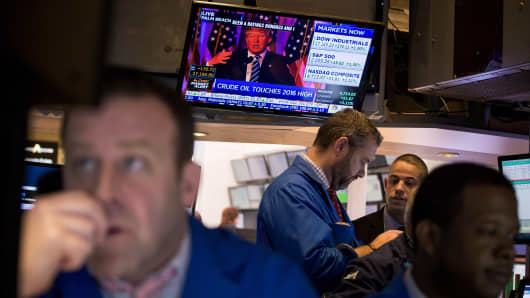 Donald Trump is seen speaking on a monitor as traders work on the floor of the New York Stock Exchange (NYSE) in New York, U.S.