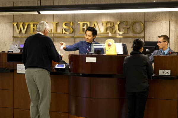 Tellers serve customers at the Wells Fargo bank in downtown Denver.