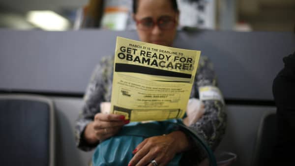 A woman reads a leafleft on Obamacare at a health insurance enrollment event