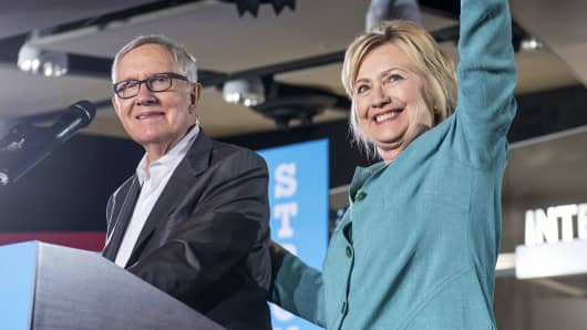 Hillary Clinton, 2016 Democratic presidential nominee, right, waves on stage with Senate Minority Leader Harry Reid, a Democrat from Nevada, during a campaign event in Las Vegas, Aug. 4, 2016.
