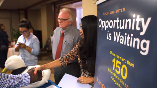 An Aflac representative, right, shakes hands with a job seeker during an Orange County Choice Career Fair in Santa Ana, California.