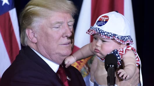 Republican presidential nominee Donald Trump holds a baby during a rally in the Special Events Center of the Florida State Fairgrounds in Tampa, Florida on November 5, 2016.