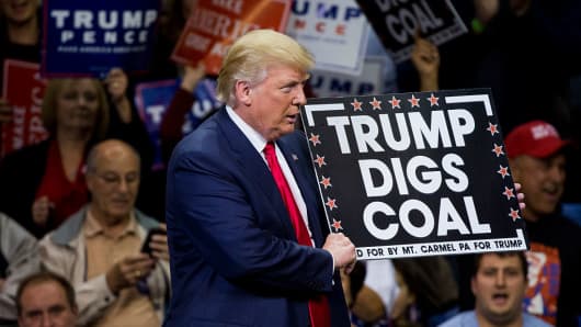 Then-Republican presidential nominee Donald Trump holds a sign supporting coal during a rally at Mohegan Sun Arena in Wilkes-Barre, Pa., on Oct. 10, 2016.