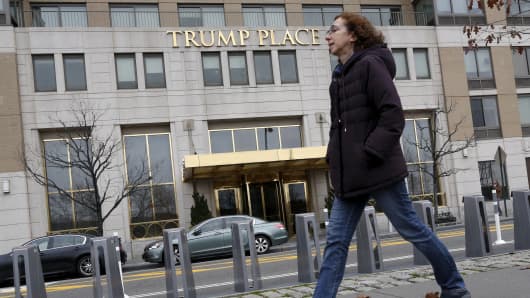 A woman walks past a Trump Place building, part of an apartment complex on the Upper West Side of Manhattan, in New York.