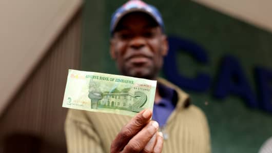 A man holds a two dollar Zimbabwean 'bond note' withdrawn in Harare, Zimbabwe on November 28, 2016.