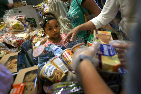 Low-income residents select free bread and produce at the Community Food Bank of New Jersey on August 28, 2015 in Egg Harbor, New Jersey.