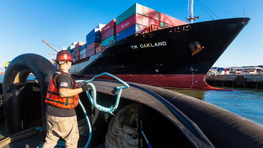 The Yang Ming Marine Transport Corp. Oakland cargo ship is guided into the Port of Oakland by a pair of AmNav tugboats as an engineer tends to mooring lines in Oakland, California.