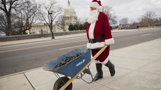 Santa Claus, also known as Sam McCrea, makes his way along 1st St., en route to the Capitol to deliver coal as a Christmas gift to Congress for their inability to reach a solution on the 'fiscal cliff.'