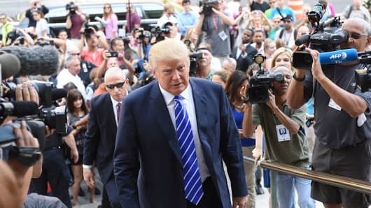 Donald Trump ascends steps of Manhattan Supreme Court surrounded by press on August 08, 2015.