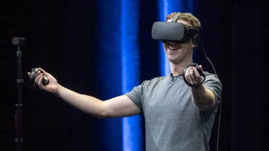 Mark Zuckerberg, chief executive officer and founder of Facebook Inc., demonstrates an Oculus Rift virtual reality (VR) headset and Oculus Touch controllers as the gives a demonstration during the Oculus Connect 3 event in San Jose, California