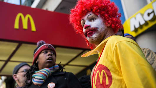 A man named Ben, who chose not to give his last name, dressed as the McDonald's mascot Ronald McDonald, participates in a protest for higher wages for fast food workers in New York City.