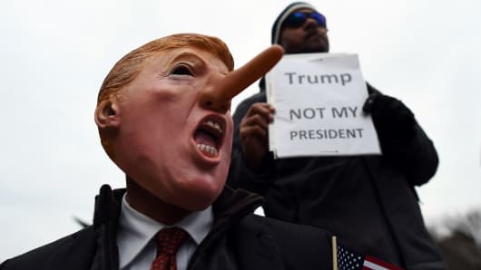 Demonstrators protest against US President-elect Donald Trump before his inauguration on January 20, 2017, in Washington, DC.