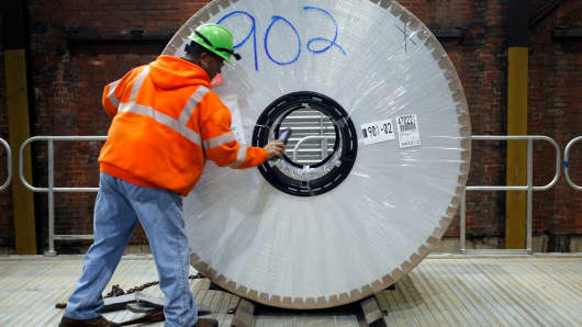 A worker loads an aluminum coil onto a loading dock at the Arconic manufacturing facility in Alcoa, Tennessee.