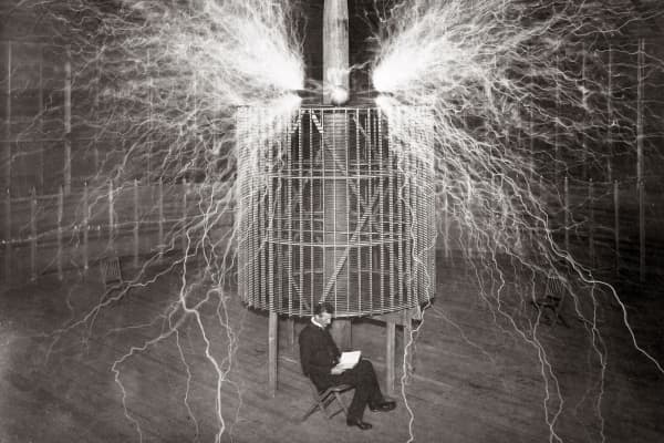 Nikola Tesla sitting in his Colorado Springs laboratory with his 'Magnifying transmitter' in 1899.